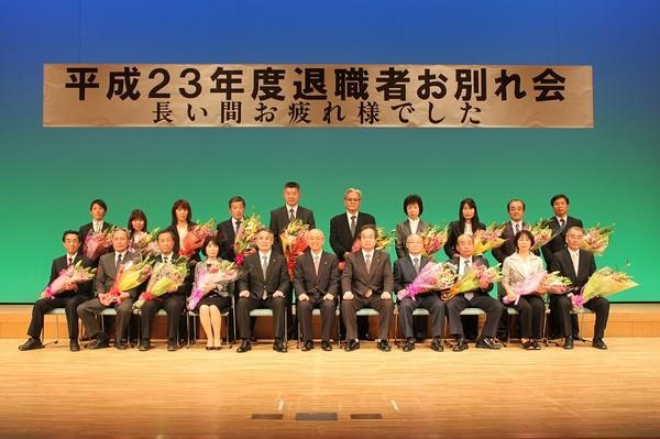 市長ら関係者と花束を抱えている退職者の方たちが記念撮影をしている写真